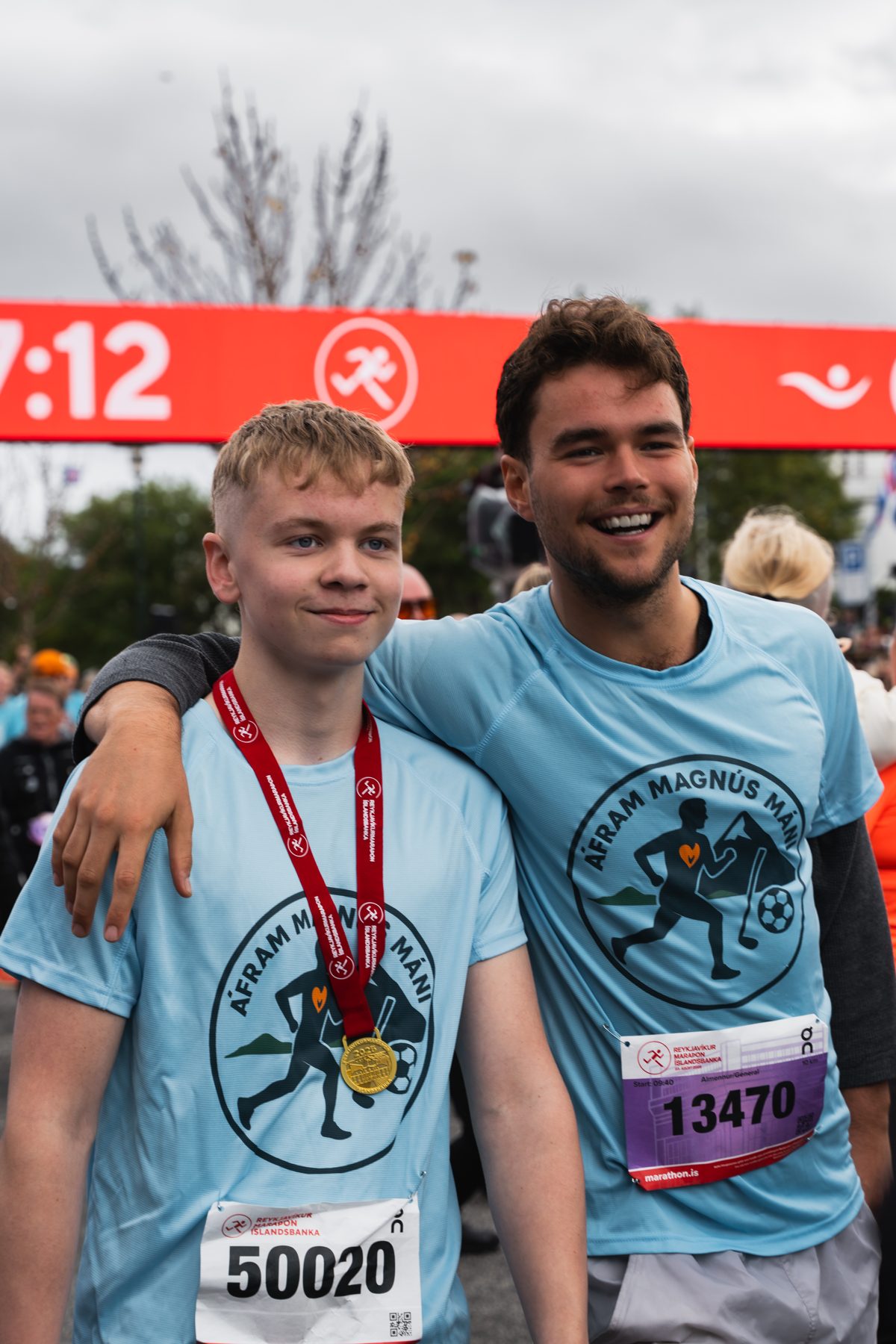 Tveir strákar arm í arm með medalíur eftir hlaupið